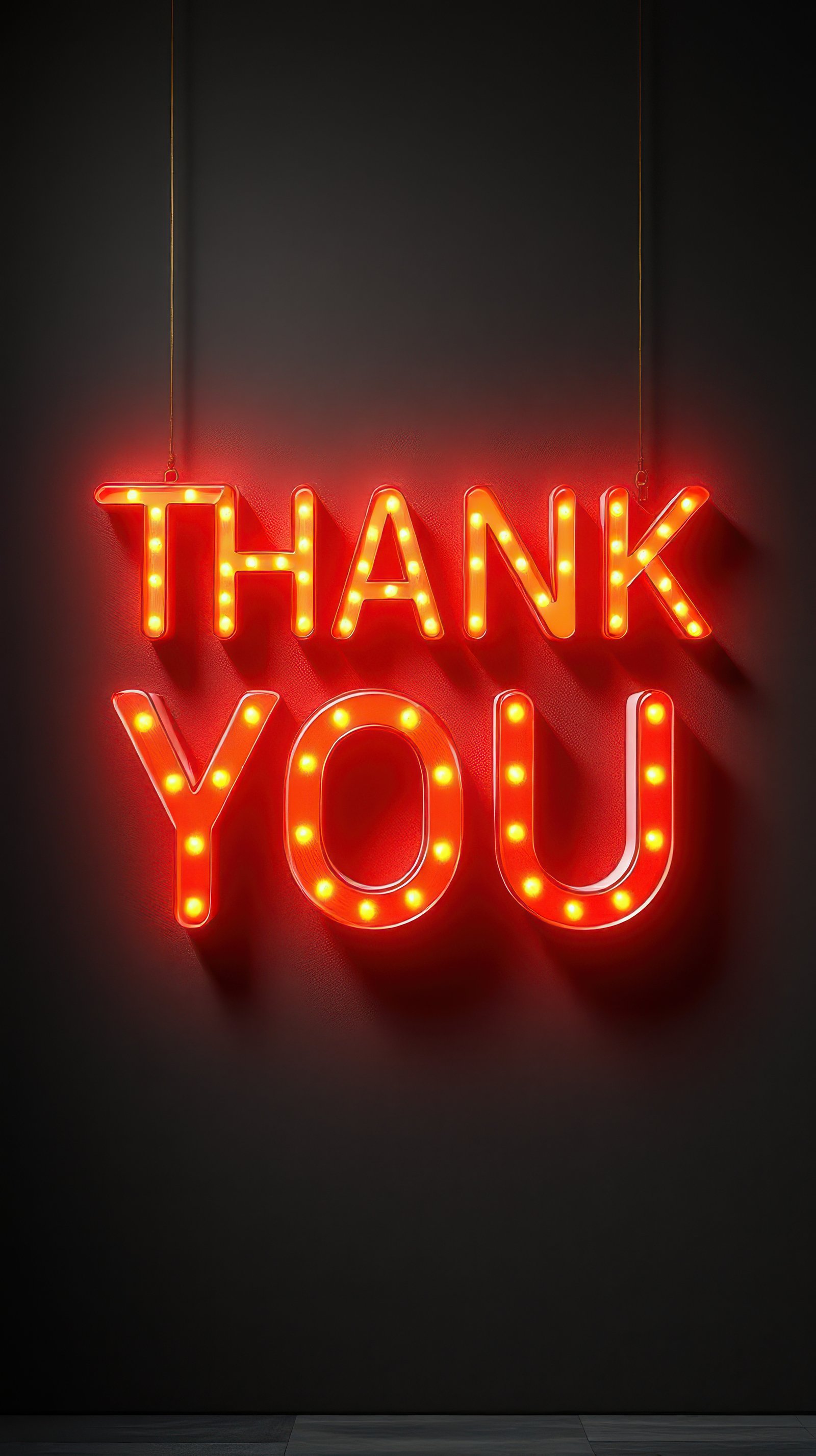 Bright neon sign displaying the phrase thank you in vibrant colors against a dark background